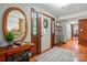 Welcoming entryway featuring hardwood floors, a decorative mirror, and a view of the stone fireplace accent wall at 7204 E 218 Hwy, Marshville, NC 28103