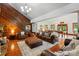 Expansive living room featuring a stone fireplace, wood-paneled walls, hardwood floors, and an adjacent game area at 7204 E 218 Hwy, Marshville, NC 28103