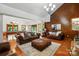 Open-concept living area with a wood-paneled wall, stone fireplace, hardwood floors, and a game room in background at 7204 E 218 Hwy, Marshville, NC 28103
