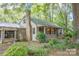 Charming home featuring a stone chimney, covered porch, and lush greenery at 749 N Miller Ave, Statesville, NC 28677