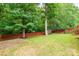 Large, well-maintained backyard with mature trees, a wooden shed, and a privacy fence at 8120 Vermilion Dr, Charlotte, NC 28215