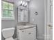 Bathroom featuring a white vanity with granite countertop, framed mirror, and natural light at 8120 Vermilion Dr, Charlotte, NC 28215