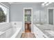 Bathroom featuring a soaking tub, a granite-topped vanity, and an ensuite view to the bedroom at 8120 Vermilion Dr, Charlotte, NC 28215
