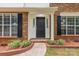 A close up view of the front door and its surrounding brickwork and flower beds at 8120 Vermilion Dr, Charlotte, NC 28215