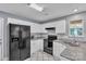 Well-lit kitchen with white cabinets, granite countertops, and black appliances at 8120 Vermilion Dr, Charlotte, NC 28215