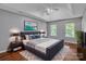 Well-decorated primary bedroom featuring a large bed, stylish decor, and hardwood floors at 8120 Vermilion Dr, Charlotte, NC 28215