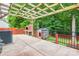 Outdoor patio area featuring a built-in brick grill, dog house, and wooden pergola with metal fencing at 8120 Vermilion Dr, Charlotte, NC 28215