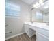Bathroom featuring a double sink vanity, large mirror, and wood look floors at 8125 Sheringham Way, Charlotte, NC 28227