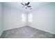 This bedroom has two windows, neutral paint and carpet and a ceiling fan at 8125 Sheringham Way, Charlotte, NC 28227