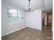 Dining room featuring a chandelier, window with view, and access to the kitchen at 8125 Sheringham Way, Charlotte, NC 28227