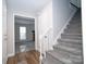 Foyer featuring hardwood flooring and carpeted stairs, and view into the Living Room at 8125 Sheringham Way, Charlotte, NC 28227