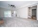 Spacious living room with a ceiling fan, sliding glass doors, and view of entry and stairway at 8125 Sheringham Way, Charlotte, NC 28227