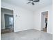 This living room has neutral walls and carpet, plus a ceiling fan, and doorways on two walls at 8125 Sheringham Way, Charlotte, NC 28227