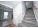 Bright stairway featuring gray carpet, white railing, and natural wood handrail leading to the upper level at 8125 Sheringham Way, Charlotte, NC 28227