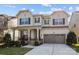 Two-story home with a porch, two-car garage, and dark-framed windows, surrounded by manicured landscaping at 840 Pecan Tree Ln, Fort Mill, SC 29715