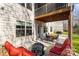 Covered outdoor patio with dining set and red cushioned seating area and a backyard view at 840 Pecan Tree Ln, Fort Mill, SC 29715
