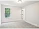 Neutral bedroom showcasing large window and plush carpeting at 8521 Aspen Ct, Charlotte, NC 28227