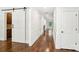 Hallway with hardwood floors and sliding barn door leading to another room at 8521 Aspen Ct, Charlotte, NC 28227