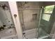 Modern bathroom with a gray stone tiled shower, glass door, brushed fixtures, and a marble top vanity at 9300 Surrey Rd, Mint Hill, NC 28227