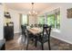Bright dining room featuring a large window, hardwood floors, and a stylish chandelier above an 8-seater table at 9300 Surrey Rd, Mint Hill, NC 28227