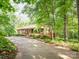 Wooded home with a long driveway and a front porch, secluded in a heavily-wooded landscape at 9300 Surrey Rd, Mint Hill, NC 28227