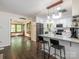Bright kitchen featuring white cabinetry, marble countertops, and a breakfast bar leading into the living room at 9300 Surrey Rd, Mint Hill, NC 28227