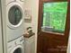 Functional laundry room featuring a stacked washer and dryer, with a wood countertop and ample storage space at 9300 Surrey Rd, Mint Hill, NC 28227