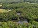 Picturesque aerial view of a house overlooking a serene lake surrounded by lush, mature trees at 1010 Arabian Farm Rd, Clover, SC 29710