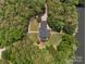 Breathtaking aerial view of a home with pristine landscaping, framed by dense green trees and waterfront access at 1010 Arabian Farm Rd, Clover, SC 29710