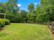 Large, grassy backyard is enclosed by a wooden fence and lush trees at 1010 Arabian Farm Rd, Clover, SC 29710