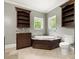 Elegant bathroom featuring a soaking tub, dark wood cabinets, and dual windows for natural light at 1010 Arabian Farm Rd, Clover, SC 29710