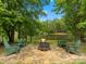 Scenic lakeside stone patio featuring an inviting firepit and Adirondack chairs surrounded by lush greenery at 1010 Arabian Farm Rd, Clover, SC 29710