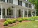 Charming front porch with hanging ferns, rocking chairs, and meticulously manicured landscaping at 1010 Arabian Farm Rd, Clover, SC 29710