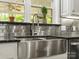 Close-up of the kitchen sink, with granite countertop and stainless steel backsplash at 1010 Arabian Farm Rd, Clover, SC 29710