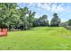 A spacious green backyard is surrounded by mature trees at 10945 Wiltshire Ln, Charlotte, NC 28262