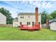 The home features a wood deck, a brick chimney, and a spacious green backyard at 10945 Wiltshire Ln, Charlotte, NC 28262