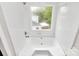 Bright bathroom features a bathtub with shower and a window with verdant outdoor views at 10945 Wiltshire Ln, Charlotte, NC 28262
