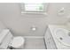 Well-lit bathroom features a toilet, sink, and a window for natural light at 10945 Wiltshire Ln, Charlotte, NC 28262