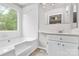 Well-lit bathroom features a soaking tub and vanity, creating a relaxing and functional space at 10945 Wiltshire Ln, Charlotte, NC 28262
