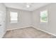 A carpeted bedroom with neutral walls, ceiling fan, and natural light from two windows at 10945 Wiltshire Ln, Charlotte, NC 28262
