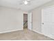 Bedroom features neutral walls and carpet, ceiling fan, and natural light at 10945 Wiltshire Ln, Charlotte, NC 28262