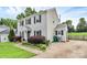 Exterior elevation features a well-manicured yard, green garbage cans, and vinyl siding at 10945 Wiltshire Ln, Charlotte, NC 28262