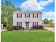 Charming two-story home featuring a well-manicured lawn and traditional design with black shutters at 10945 Wiltshire Ln, Charlotte, NC 28262