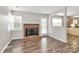 Cozy living room featuring a fireplace, natural light, and seamless flow to the kitchen at 10945 Wiltshire Ln, Charlotte, NC 28262