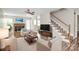 Inviting living room with a brick fireplace, plush seating, and elegant staircase at 10945 Wiltshire Ln, Charlotte, NC 28262