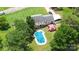 Aerial view of home featuring an inground pool, patio deck, carport, and mature trees at 1104 Colony Ct, Gastonia, NC 28056