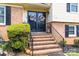 Welcoming front porch with brick steps, black railings, and decorative wreaths on glass paneled doors at 1104 Colony Ct, Gastonia, NC 28056