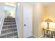 Stairway with carpeted steps and adjacent door and side table at 1104 Colony Ct, Gastonia, NC 28056