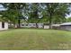 Spacious backyard featuring a large grassy area, mature trees, and a white single story home at 1109 S Highland Ave, Landis, NC 28088