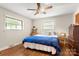 Bright bedroom with hardwood floors, a queen bed with blue comforter and two windows at 1109 S Highland Ave, Landis, NC 28088